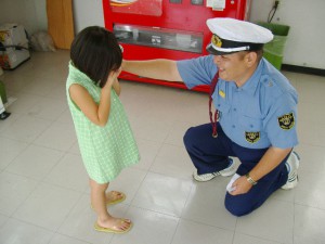 泣いている子供に対応する警備員