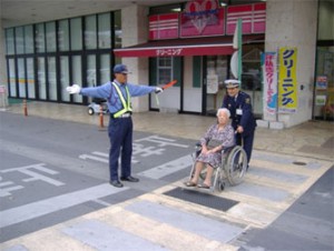 車椅子の方を安全に横断させる警備員